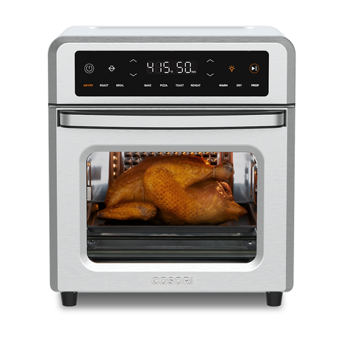Cosori 13-Quart Air Fryer Oven with a whole roasted chicken cooking inside. Stainless steel finish